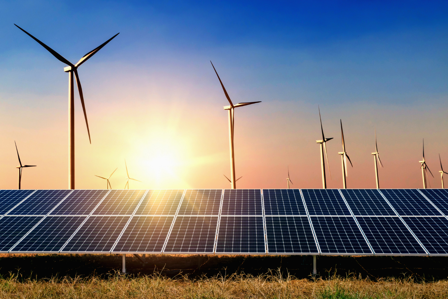 Windmills and solar panel with sun rays