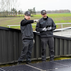 Two men in black looking at pointing