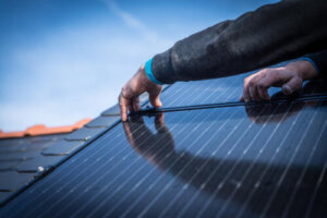 A worker is adjusting clips on solar panel.
